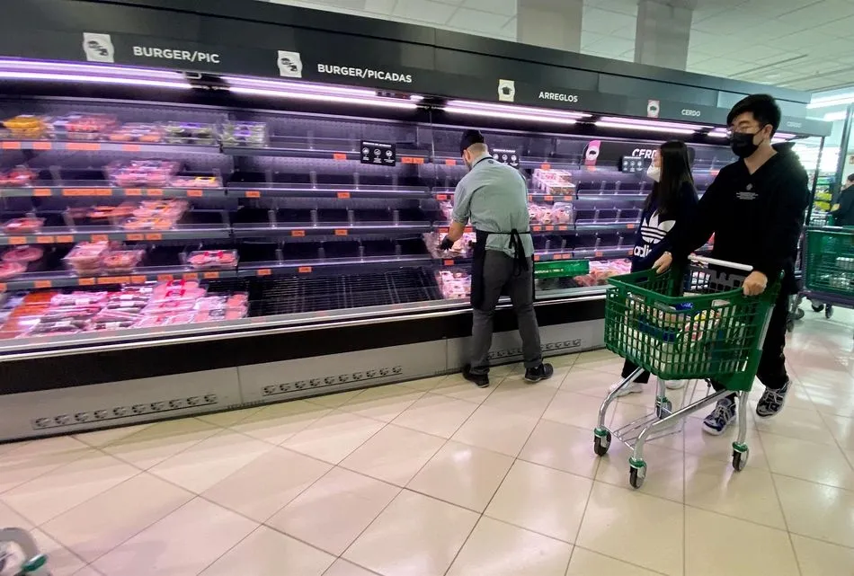 Una pareja con rasgos asiáticos y protegidos con mascarilla realizan la compra en un supermercado - Eduardo Parra - Europa Press - Archivo