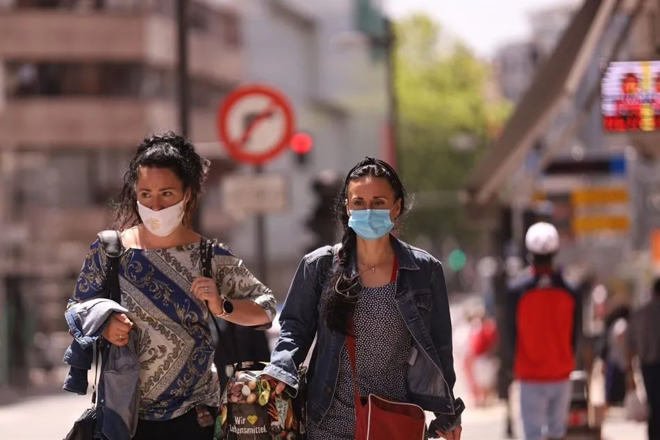 Dos mujeres con mascarilla caminan por la calle. Foto: EP
