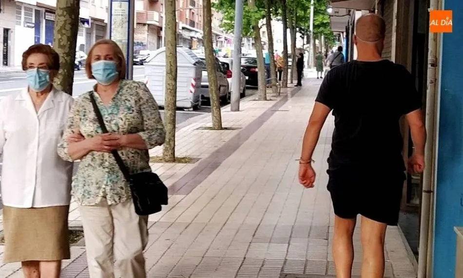 Varias mujeres con mascarilla pasean por la calle