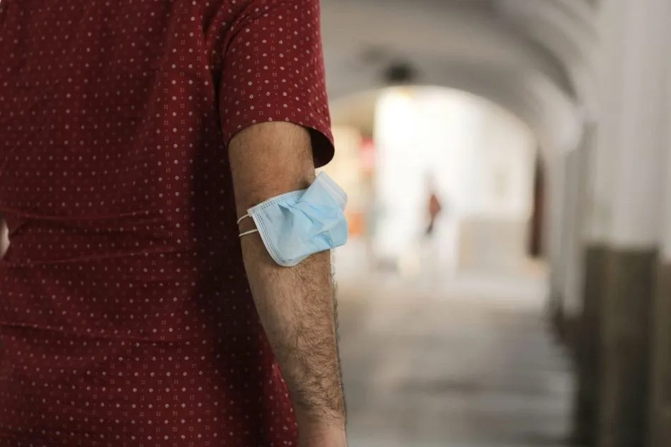 Un hombre lleva la mascarilla en el brazo en Mérida - AYUNTAMIENTO DE MËRIDA