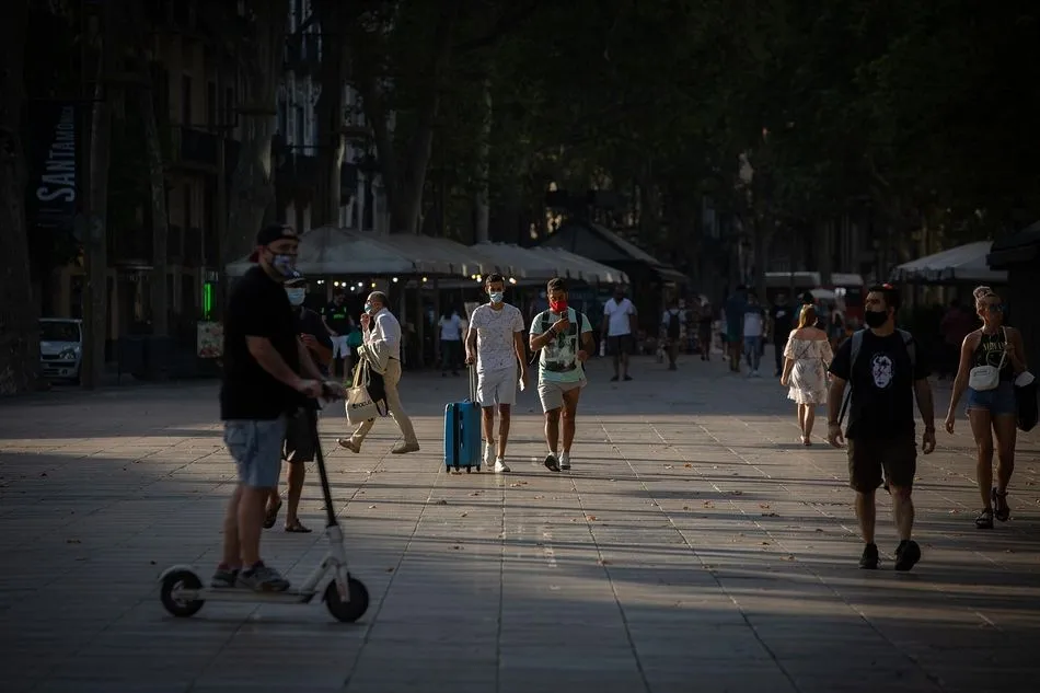 Dos jóvenes caminan con mascarillas en Barcelona - Europa Press