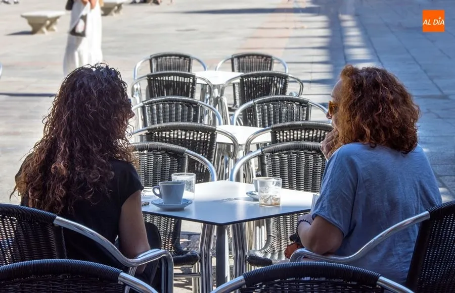 Dos mujeres conversan sentadas en una terraza de la ciudad. Foto: Lydia González
