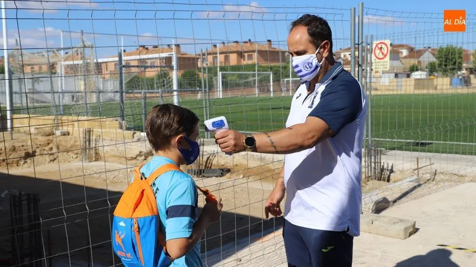 Un miembro del Cabrerizos le toma la temperatura a un niño / Lydia González