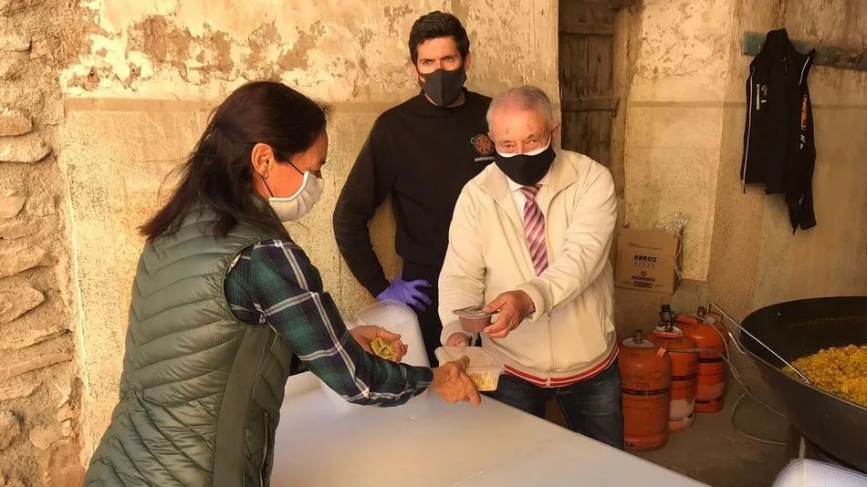 El alcalde, Bernabé Gil, se encargó del reparto en tupper de la paella y las natillas