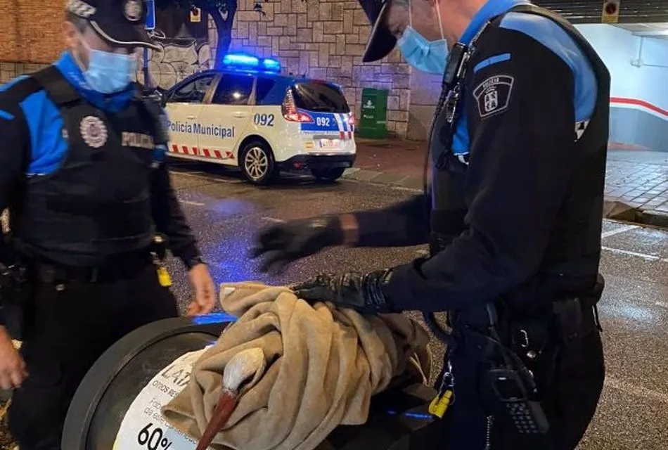 Dos agentes recogen a una cigüeña incapaz de volar por la lluvia. Foto: EP/Policía Local de Valladolid