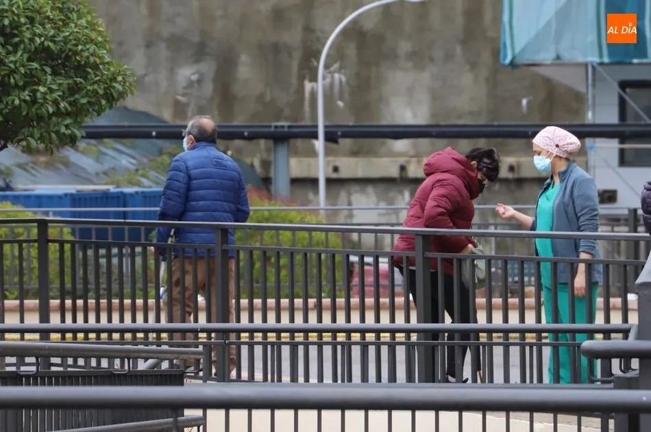 Una sanitaria charla con una usuaria en uno de los accesos al Hospital Clínico de Salamanca. Foto de archivo