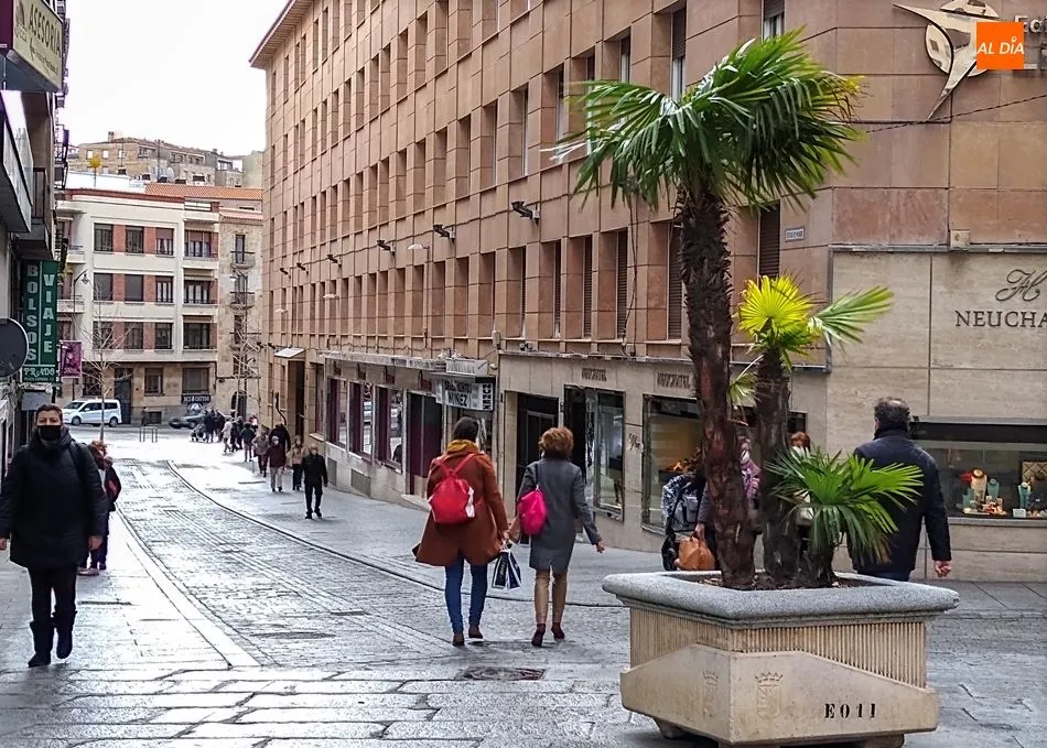 Varias personas pasean por la calle con mascarilla