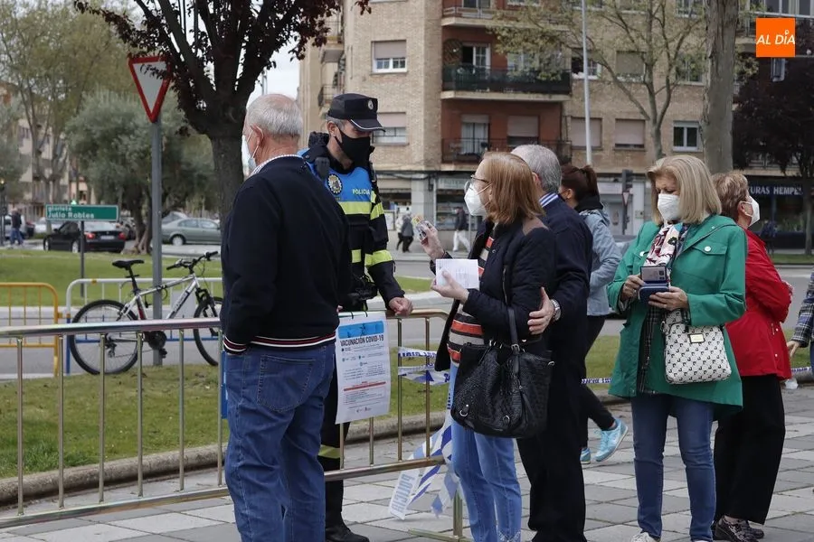 Un agente de la Policía Local atiende a algunas de las personas que esperaban su turno junto al Multiusos. Foto de Guillermo García
