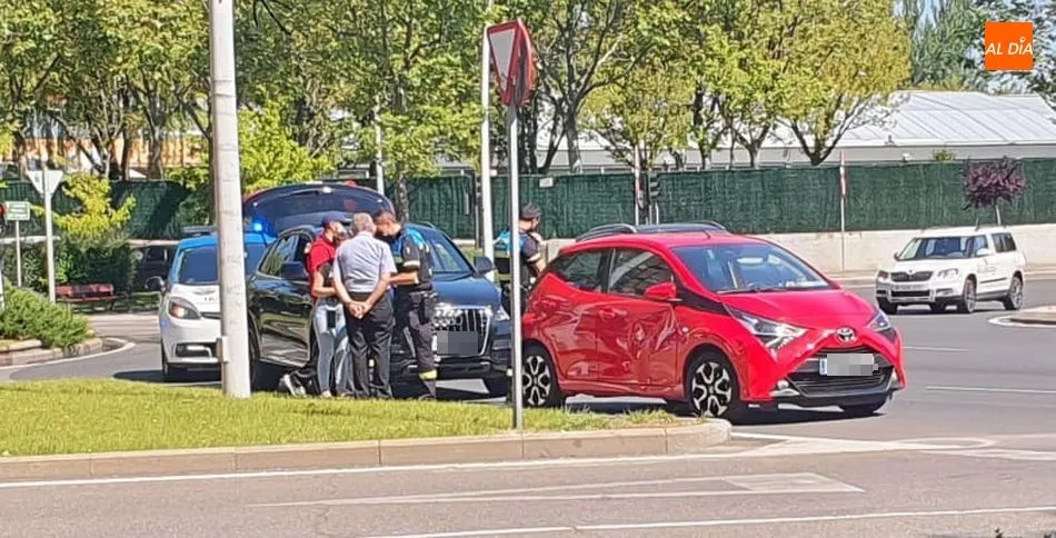 Los dos coches siniestrados, junto a los policías, en la glorieta de Castilla y León