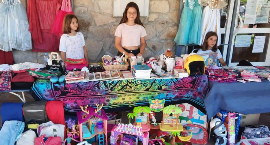 Varios niños se ponen detrás del mostrador en el mercadillo de 2ª mano de El Payo