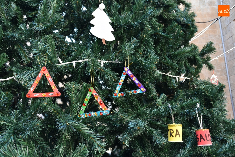 Los niños empiezan a adornar el árbol del centro de la calle Madrid