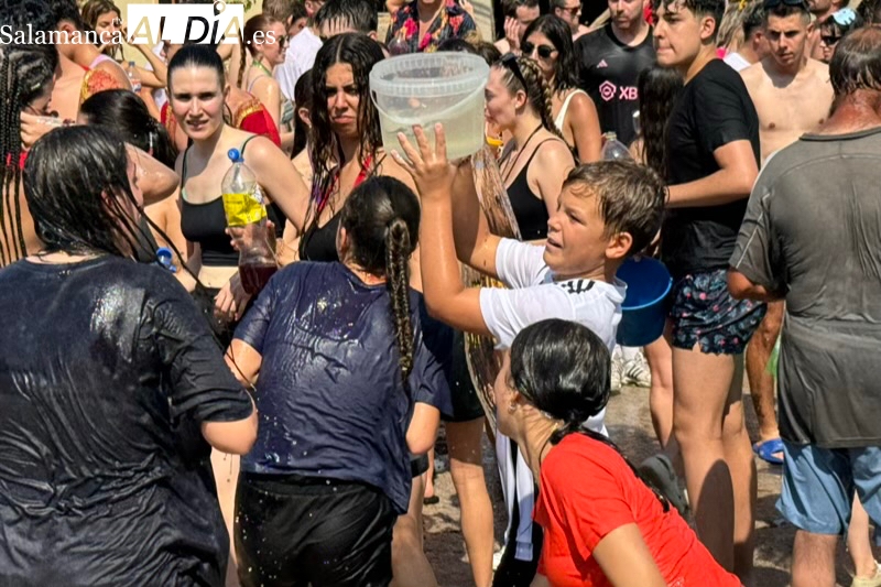 Agua, bailes y carcajadas se unen un año más en el gran pasacalles acuático en Santiago de la Puebla