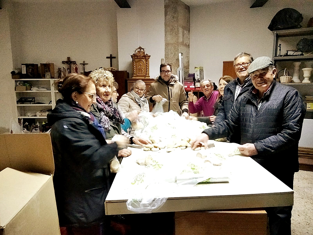 Los Cofrades de San Antón embolsan los panecillos para ponerlos a la venta