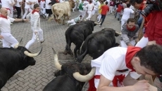Un toro engancha a un mozo durante el segundo encierro / FOTO: EFE JAVIER LIZÓN