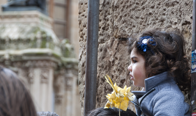 La niña observa atenta el paso de La Borriquilla | Fotos: Manuel Lamas