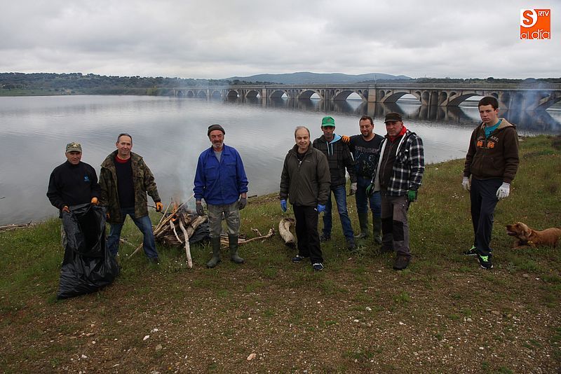 Los miembros de club de pesca de Guijuelo junto a una de las hogueras de desperdicios.