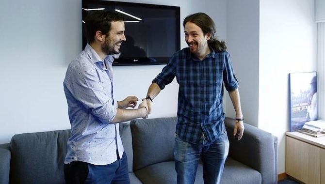 Garzón, a la izquierda, se saluda con Iglesias tras su pacto