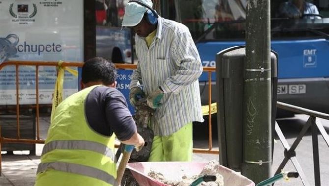 Dos personas extranjeras trabajan en la construcción