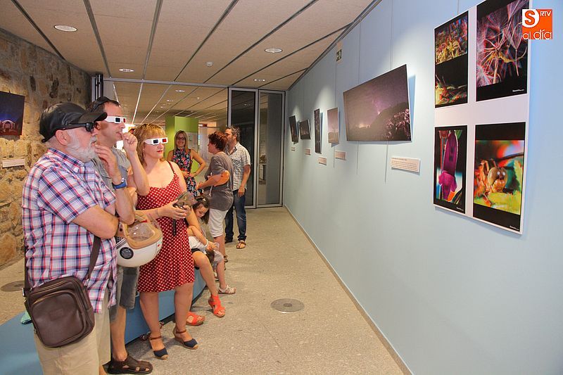 Unos visitantes usan gafas 3D para apreciar las realistas fotos de Marino Esteban.