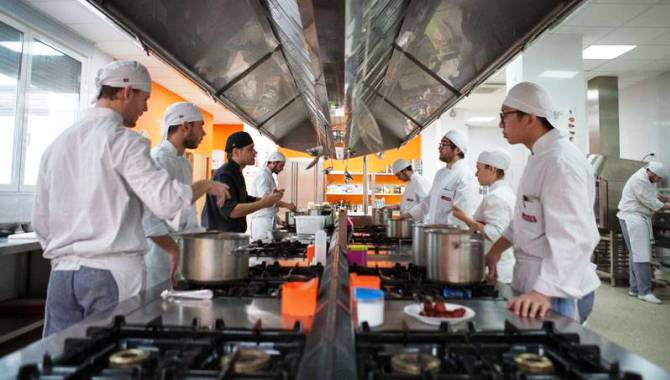 Unos alumnos atienden las explicaciones en unas clases de cocina