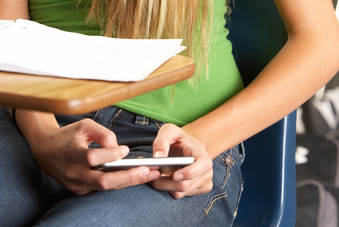 Una joven consulta su móvil