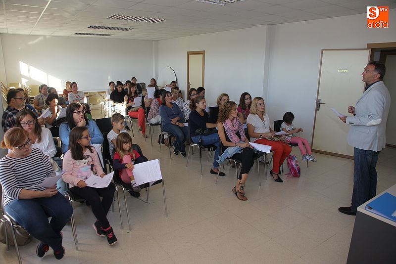 Padres y escolares atienden a las explicaciones del director de la escuela de inglés.