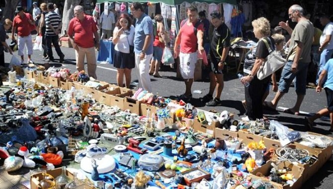 Unos viandantes ven un puesto en el rastro de La Aldehuela de Salamanca