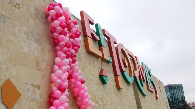 Lazo gigante con globos de color rosa en la fachada de este centro comercial