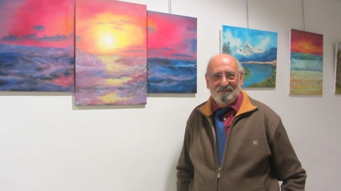 Carlos Alonso, pintor, junto a algunas de sus obras