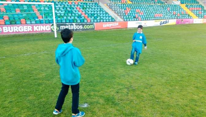 Dos niños juegan sobre el césped del estadio Helmántico