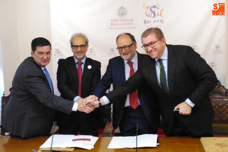 Los cuatro organizadores y representantes de las empresas se dan la mano tras la firma del convenio