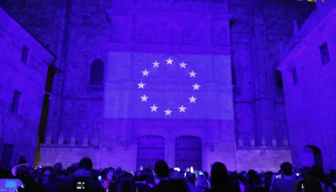 Fachada de la Universidad de Salamanca iluminada con los colores y la bandera de la UE