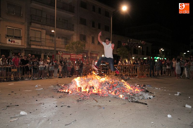 Un joven guijuelense salta sobre la hoguera en la plaza Mayor.