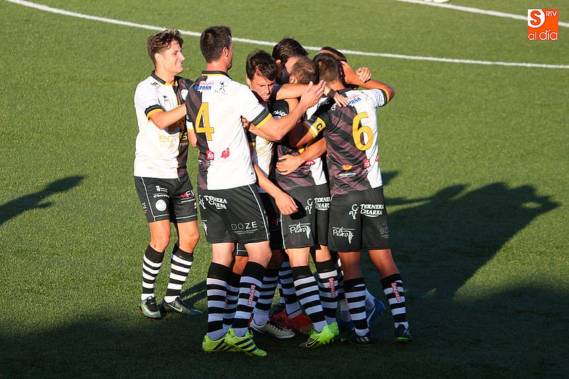 Los jugadores del Unionistas abrazan a Carmona celebrando el gol de la victoria