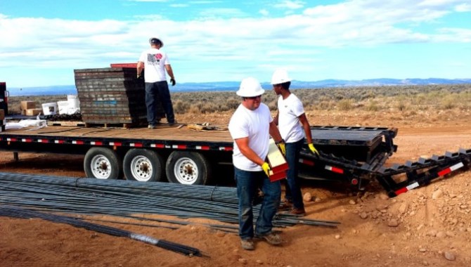 Unos trabajadores descargan un camión en una obra