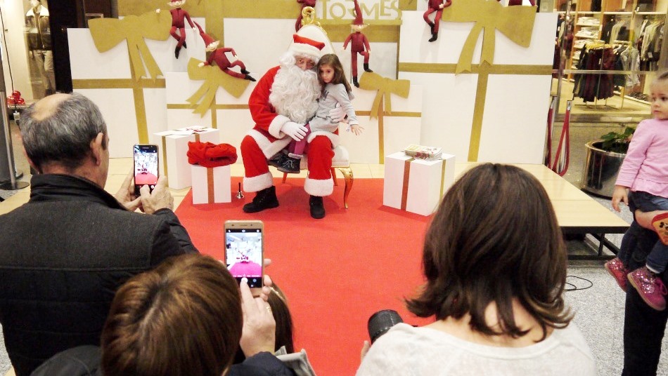 Papa Noel con una de las muchas niñas que quisieron fotografiarse con él