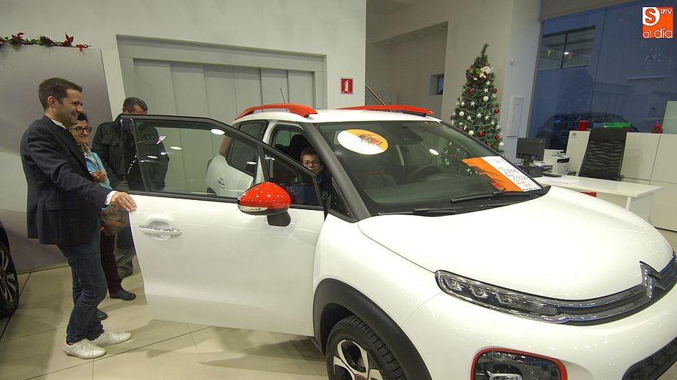 Varios clientes observan un vehículo en un concesionario en Salamanca.