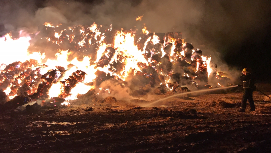 Labores de extinción para sofocar el incendio del gran montón de paja en La Vellés