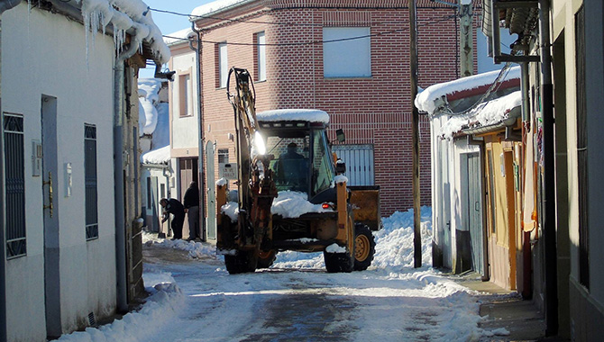 Seis operarios municipales, apoyados por un tractor, trabajan en la limpieza de calles en Macotera tras la nevada. Foto: José Guerras