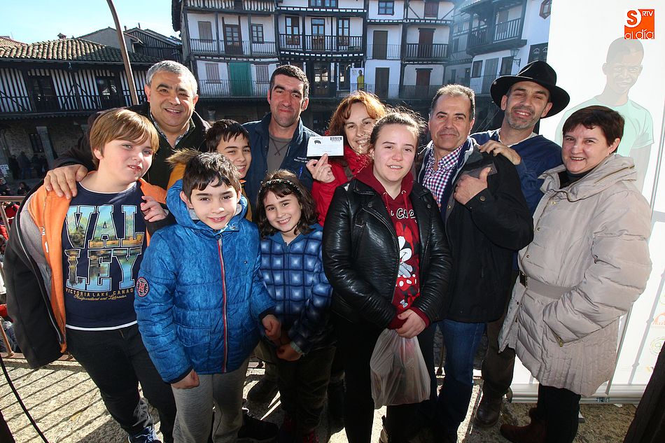 La familia ganadora posa junto con los organizadores de la rifa del marrano de San Antón de La Alberca a favor de Luz para Benín