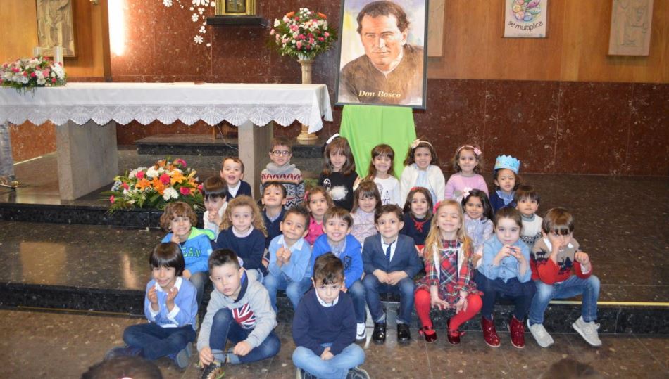 Una foto de los más pequeños con un cuadro de Dos Bosco detrás