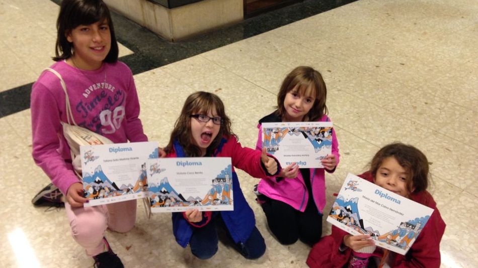 Varios niños con sus diplomas correspondientes a una actividad.
