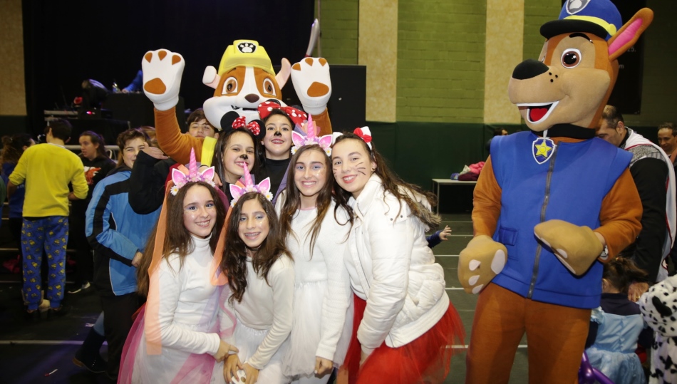Unas jóvenes posan junto a unos muñecos en la fiesta de disfraces de Carbajosa