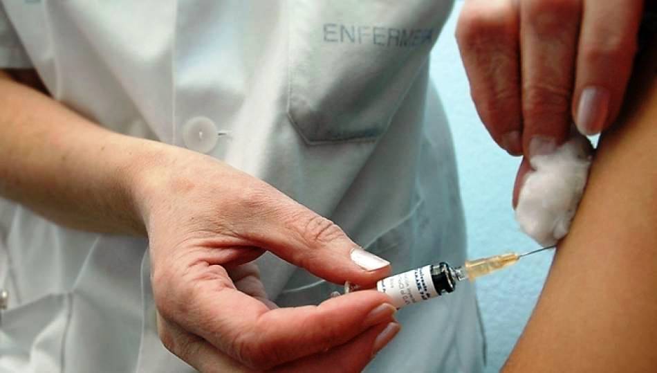 Una enfermera pone una inyección a un paciente en el Clínico