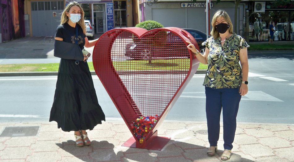 Las ediles Marta Labrador y Esther Casado, junto al nuevo contenedor para tapones de Santa Marta