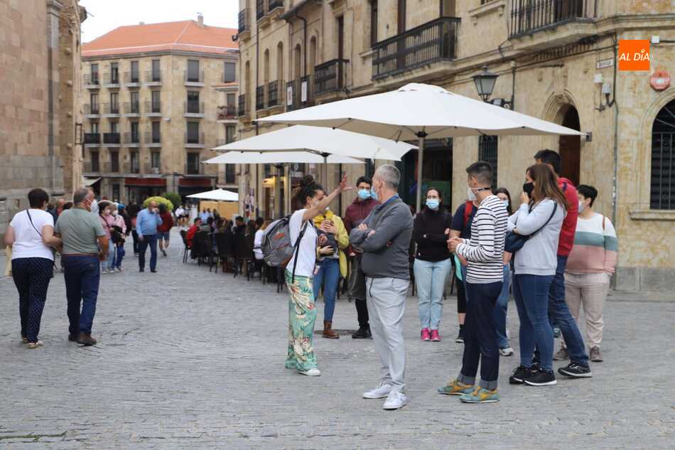 Varios grupos de personas con mascarilla paseando por la ciudad