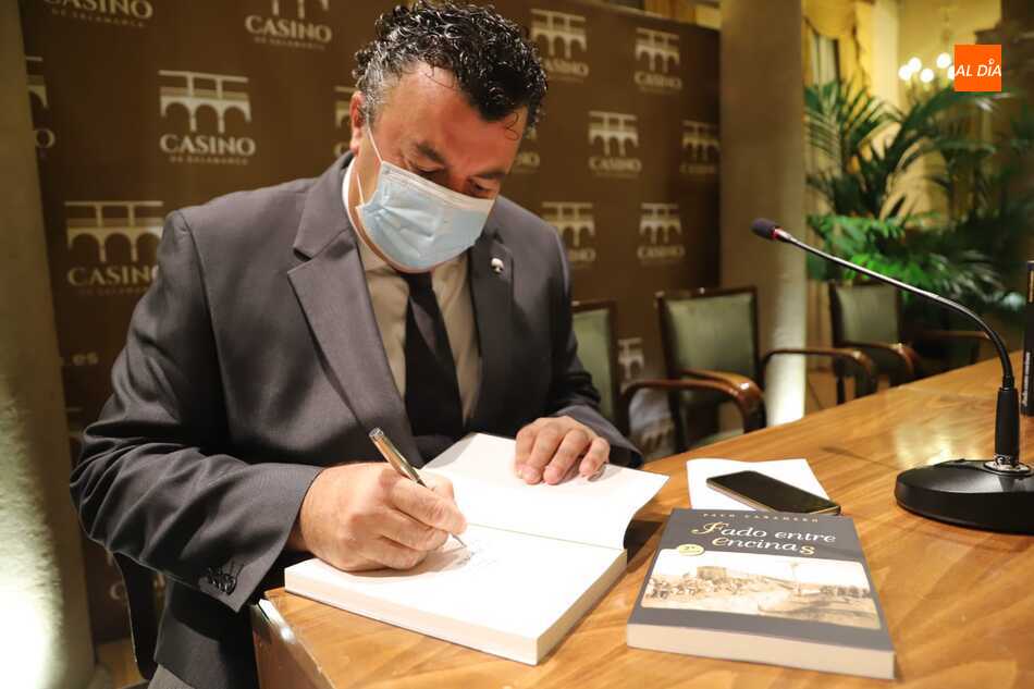 El escritor y periodista Paco Cañamero firmando uno de los ejemplares de Fado entre encinas. Foto: Lydia González