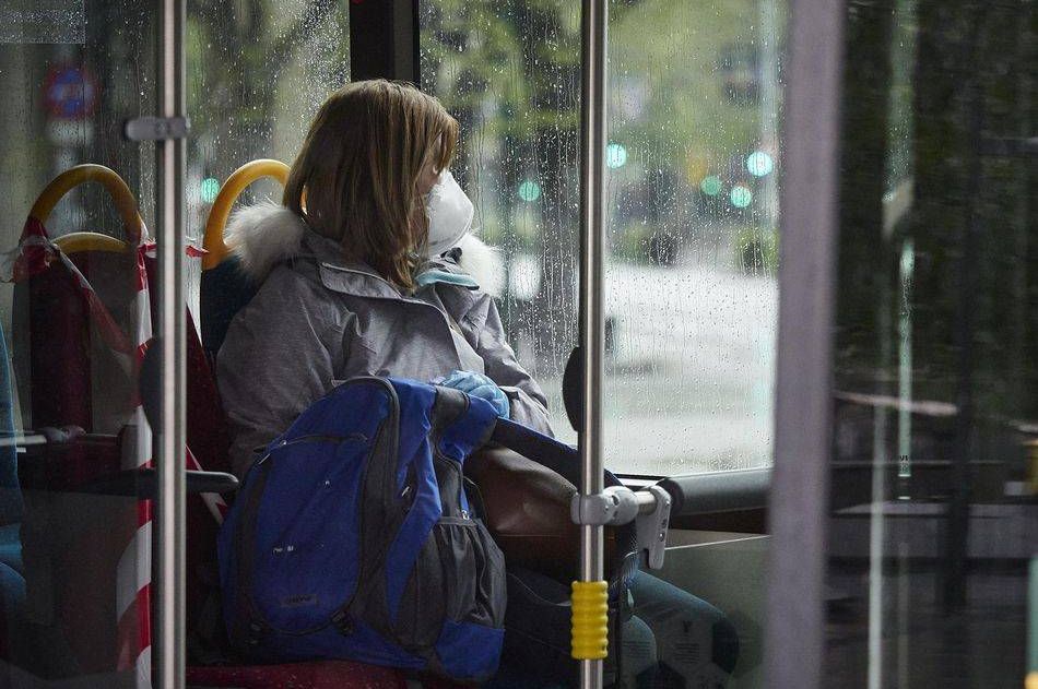 Una mujer con mascarilla en un autobús. Foto de archivo