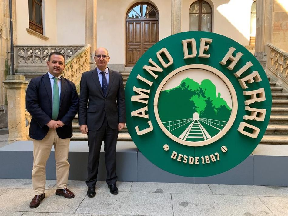 El presidente, Javier Iglesias, junto a la imagen de marca de Camino de Hierro, y el diputado de Turismo, Javier García
