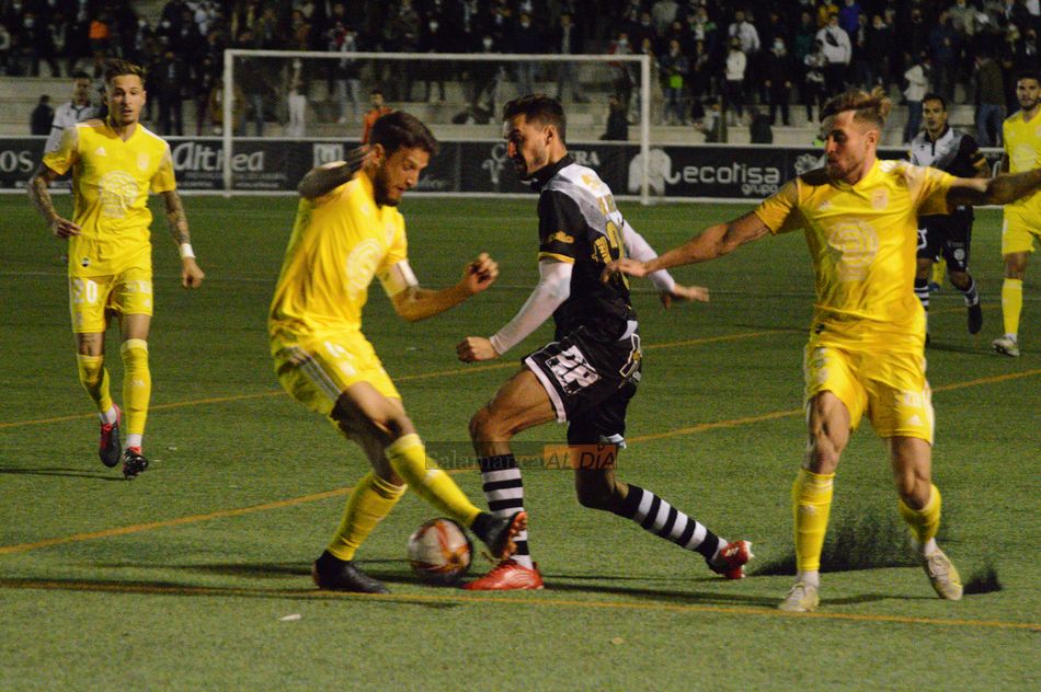 De Miguel, entre dos jugadores del Badajoz / Guillermo García